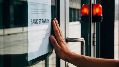 Mão pressionando vidro de porta fechada de agência bancária durante greve, com aviso colado ao vidro e reflexo da rua de fundo, representação visual de como a greve afeta FGTS e financiamento