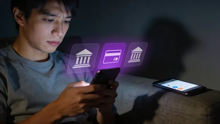 Pessoa jovem consultando app de banco no celular à noite, preocupação genuína, ícones de apps bancários na tela.